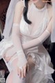 A woman in a wedding dress sitting on a chair.